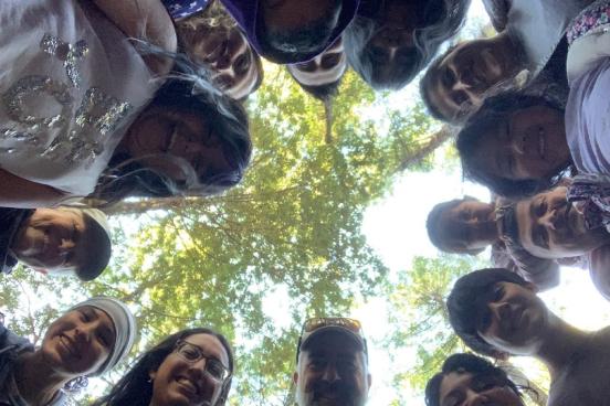 people look down at a camera with trees behind them