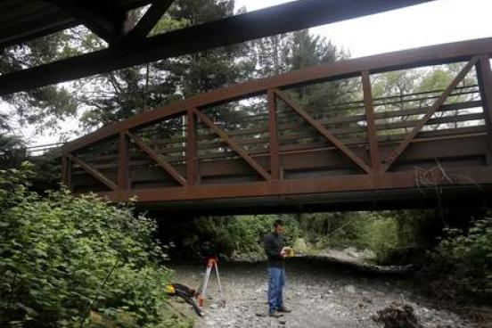 Student using a GPS device under a bridge