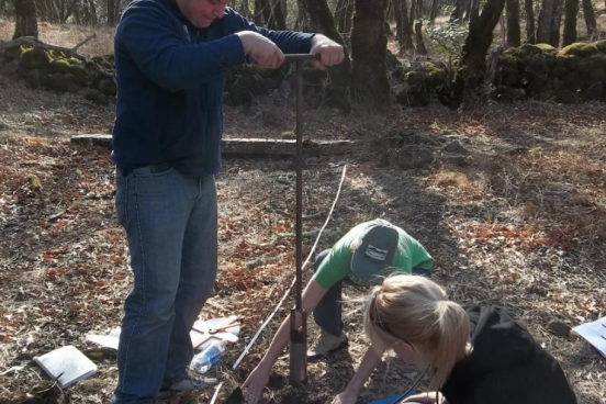 Students collecting samples with a soil auger