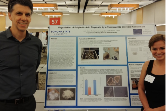 two people stand next to scientific poster