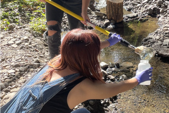 two people collecting river water