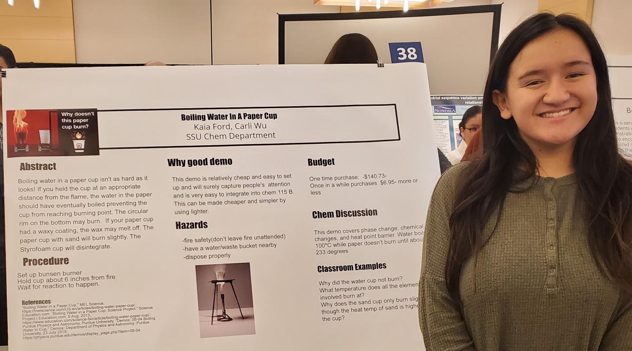 student standing next to poster
