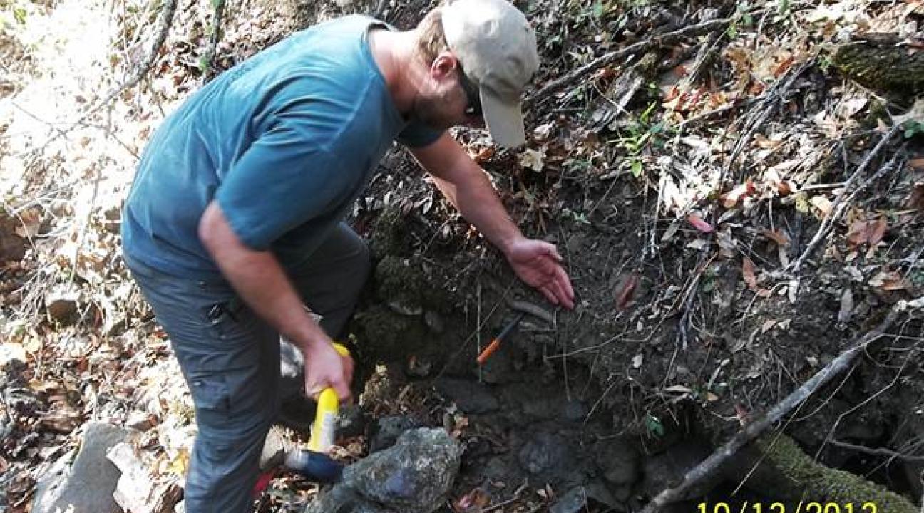 Man installing erosion pins in creek bank