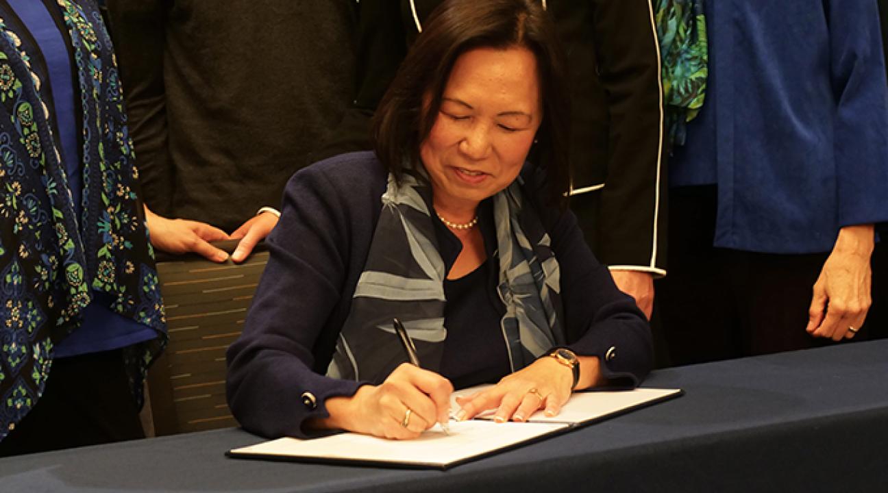 SSU president Judy Sakaki signing commitment to sustainability