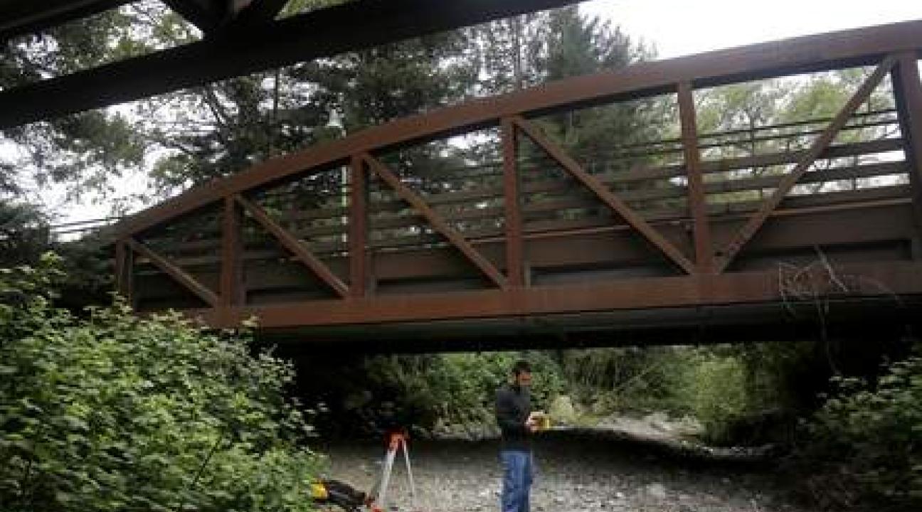 Student using a GPS device under a bridge