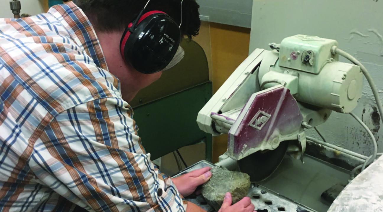 Student making a thin section from a sample of rock