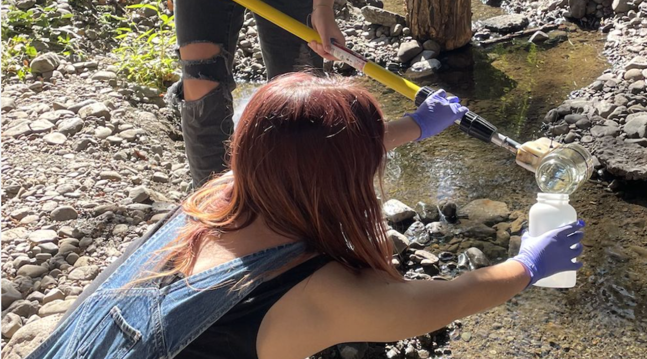 two people collecting river water