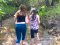 two girls running in a creek