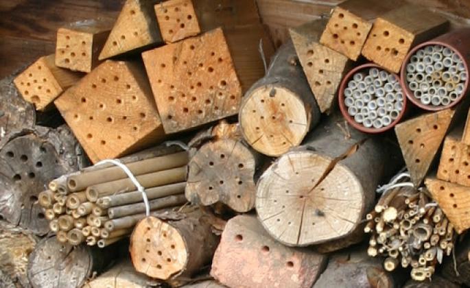 a variety of homemade bee houses in a pile