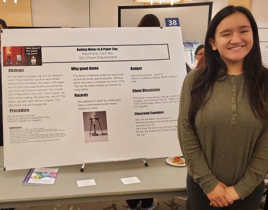 student standing next to poster