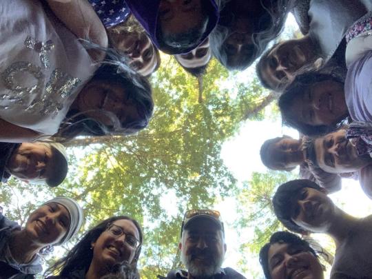 people look down at a camera with trees behind them