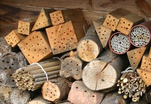 a variety of homemade bee houses in a pile