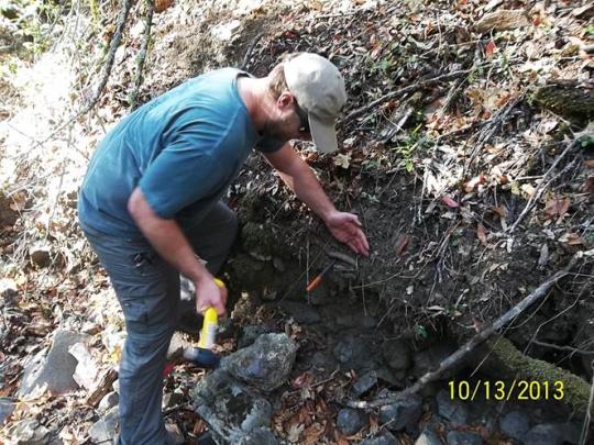 Man installing erosion pins in creek bank