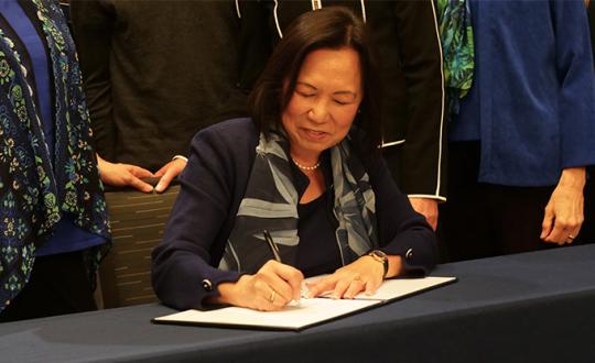 SSU president Judy Sakaki signing commitment to sustainability