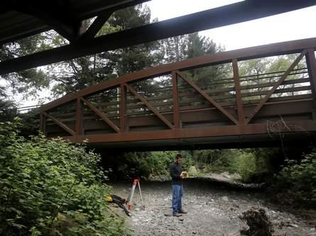 Student using a GPS device under a bridge