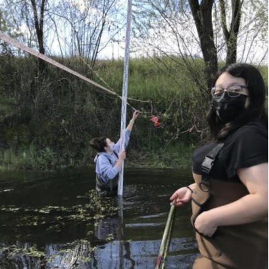 students take measurements in a creek