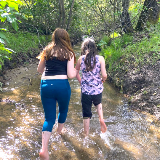 two girls running in a creek