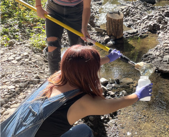 two people collecting river water