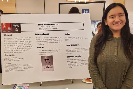 student standing next to poster